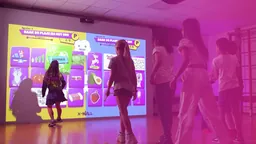 Bezoekers spelen met de interactieve X-Wall in roze licht