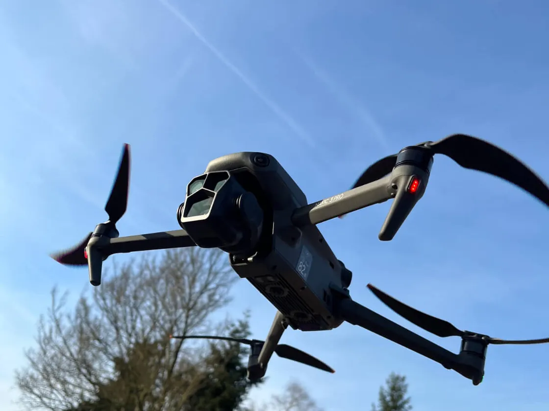 Een drone in de lucht boven bomen en daken