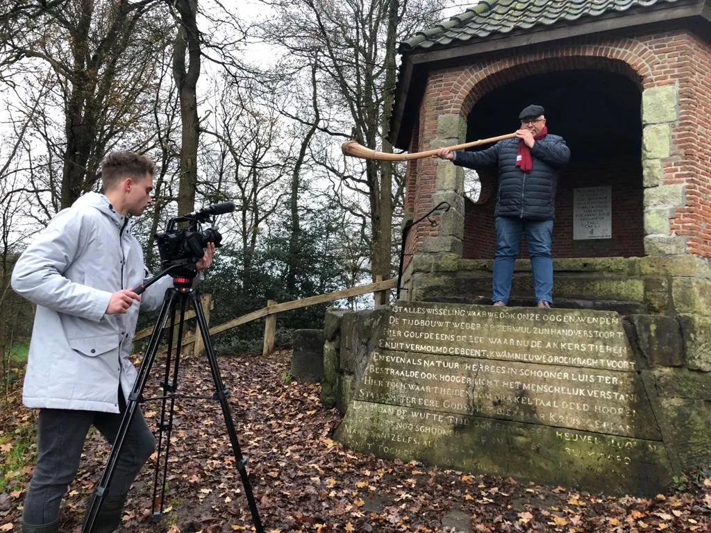 Opnames voor een kerstvideo bij een klein bakstenen gebouw