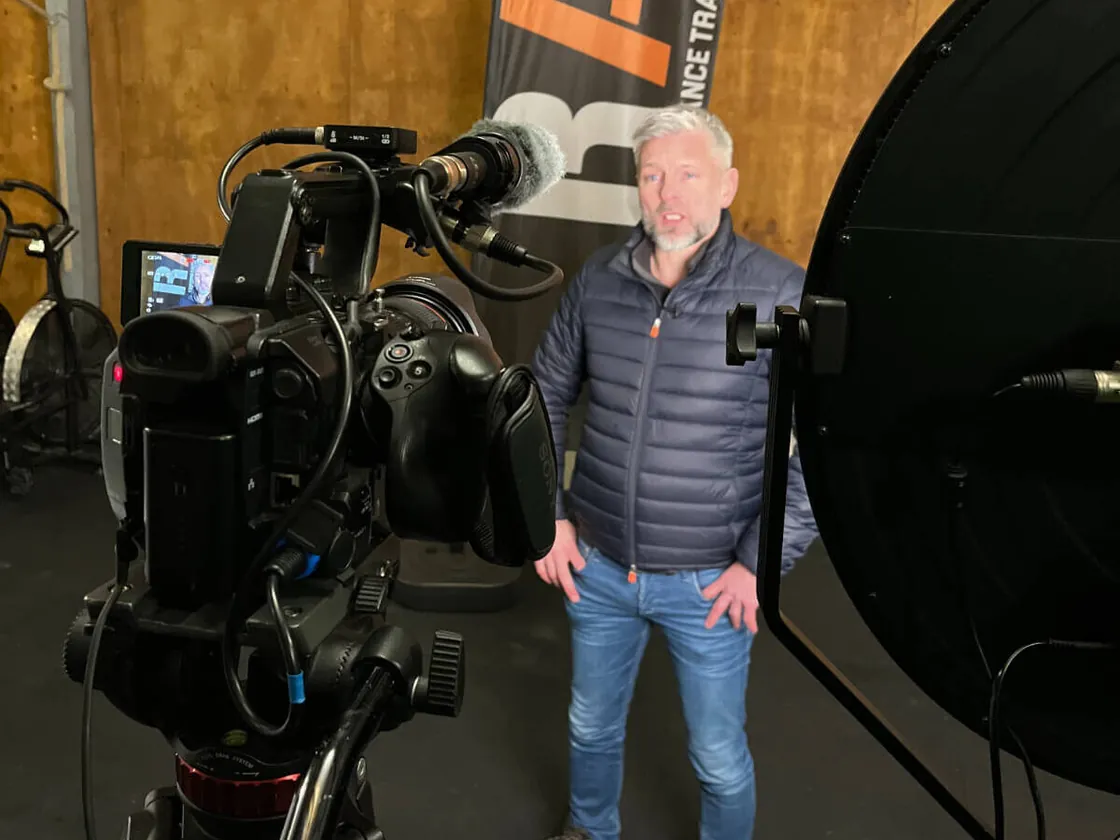 Video-opname in een studio met een man voor de camera en studiolampen