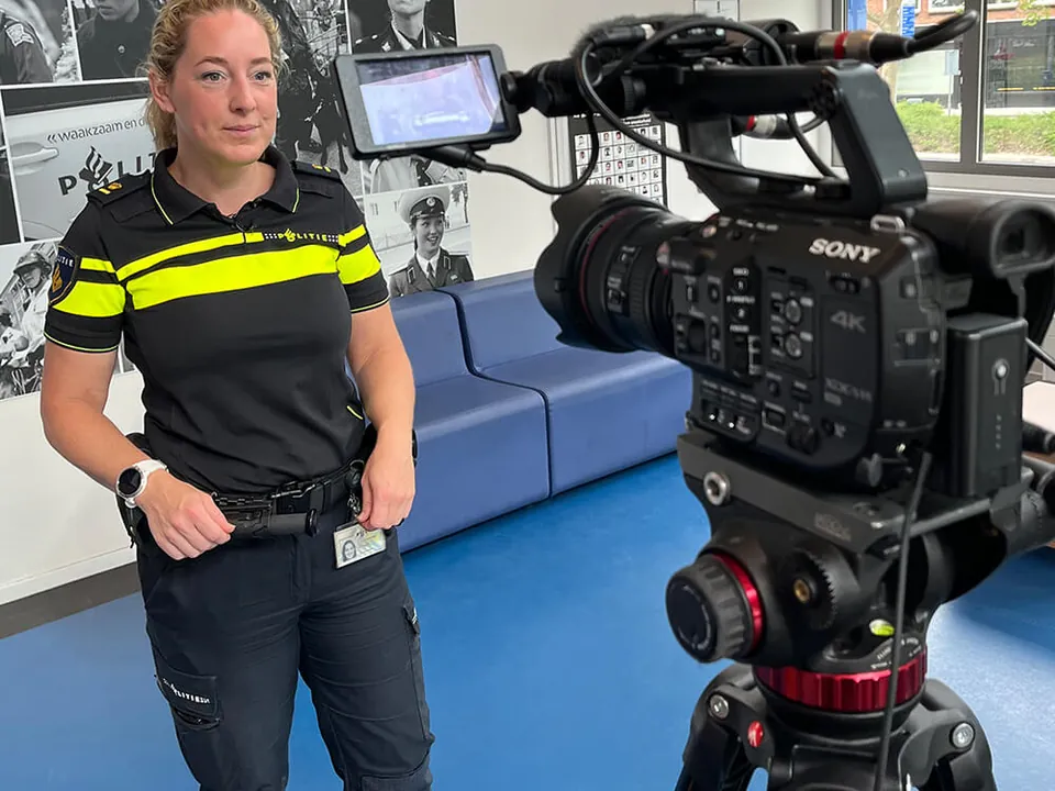 Politieagent in uniform voor de camera tijdens een video-opname