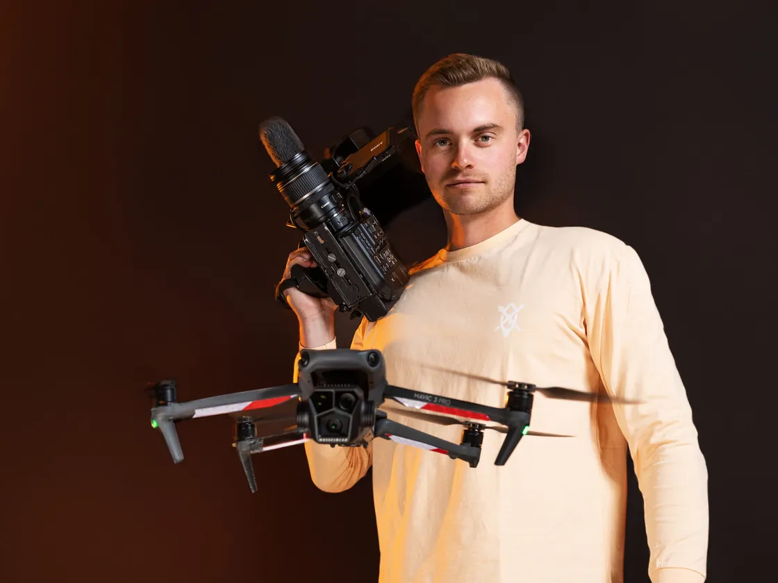 Cars Bijlstra met een drone en een videocamera, voor een oranje achtergrond